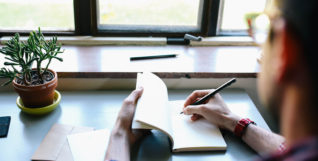 Man writing by window